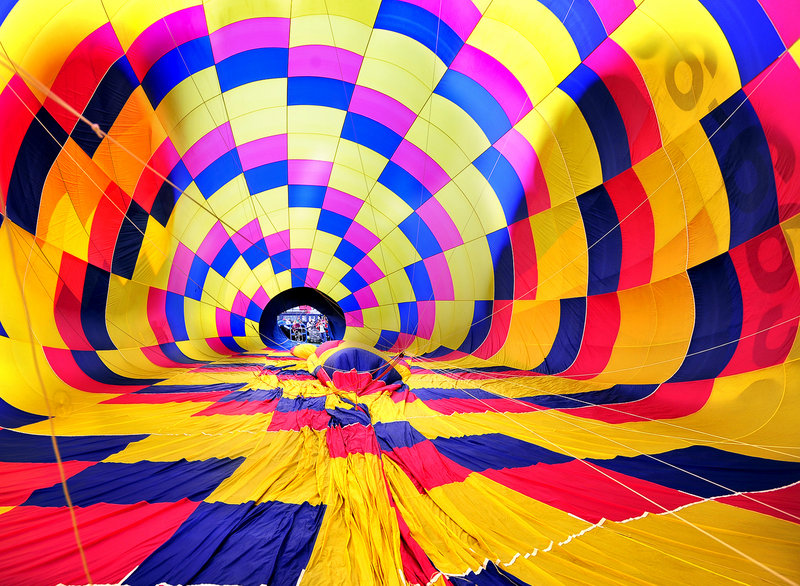 A hot air balloon owned and piloted by Andre Boucher of Derry, N.H., starts to inflate with air from high-powered fans at Railroad Park in Lewiston.