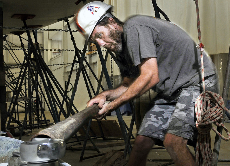 Darrin Low uses a bar to get extra tourque as he works on the Baraka, a lightweight racer-cruiser, at Lyman-Morse Boatbuilders in Thomaston. In the last 30 years, Lyman-Morse has launched nearly 100 vessels, most ranging from roughly 25 feet to 60 feet in length.