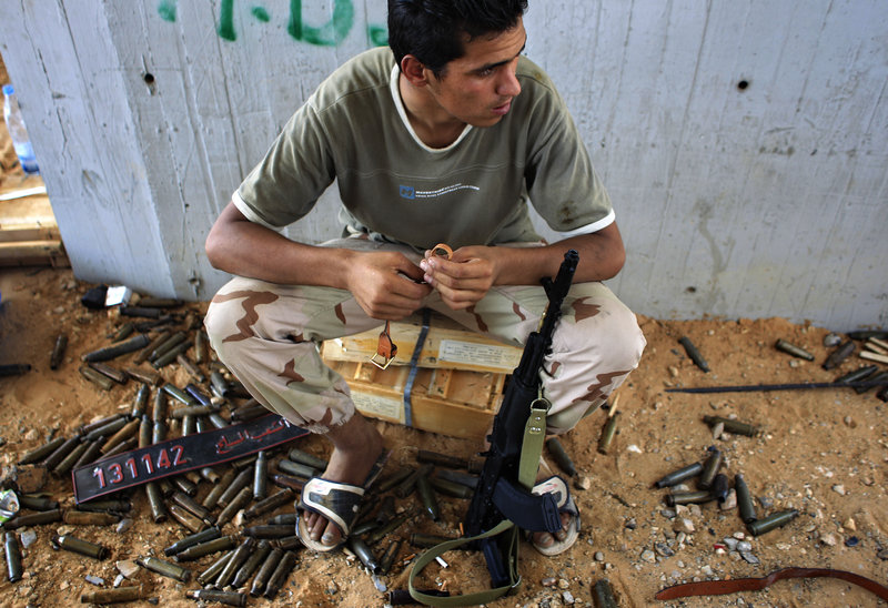 A rebel fighter sits at the checkpoint near the Tripoli International Airport outside Tripoli, LIbya, on Friday. At least 230 were killed and hundreds wounded in the five-day takeover.