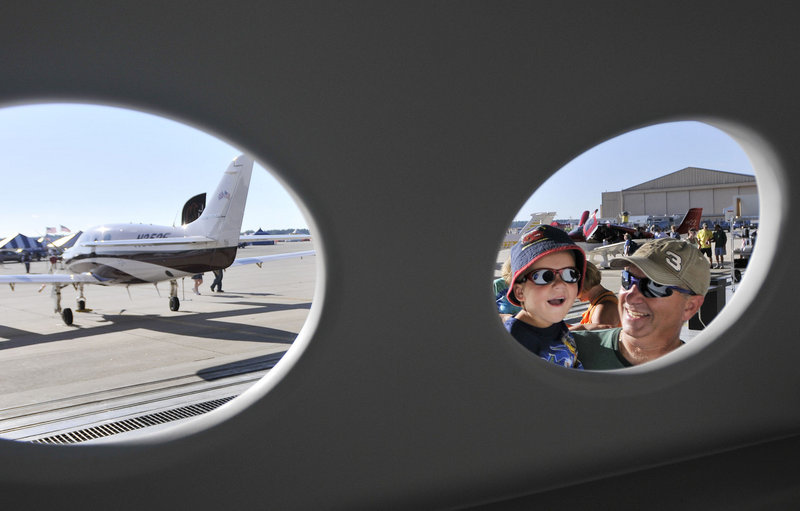 Duane Godsoe of New Brunswick holds up his son Jayden, 3, to look into an example of a fuselage made by the Kestrel Aircraft Co. on display during the Great State of Maine Air Show at the former Brunswick Naval Air Station on Friday.