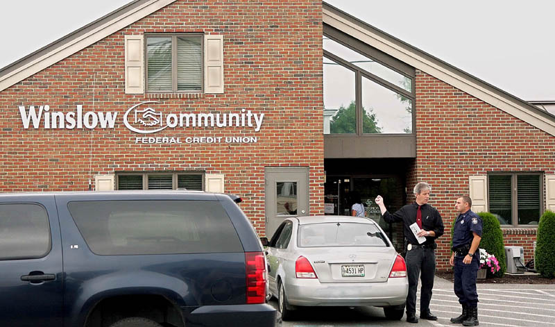 ROBBERY IN WINSLOW: Winslow Police Chief Jeffrey Fenlason talks with a State Police officer following a robbery at the Winslow Community Federal Credit Union on Monument Street Thursday morning. State and local police were searching for a suspect described as white male with a striped hooded sweatshirt.
