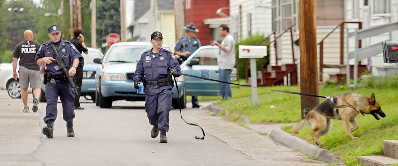 SEARCHING FOR A SUSPECT: A Maine State Police K-9 unit searches along LaSalle Street for the man that robbed the Winslow Community Federal Credit Union on nearby Monument Street Thursday morning.