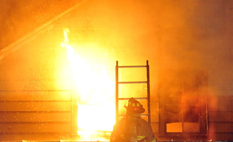 Staff photo by Michael G. Seamans Firefighters from Waterville and WinslowFire Departments responded to a structure fire on Water Street Monday evening. The apartment building was a total loss.