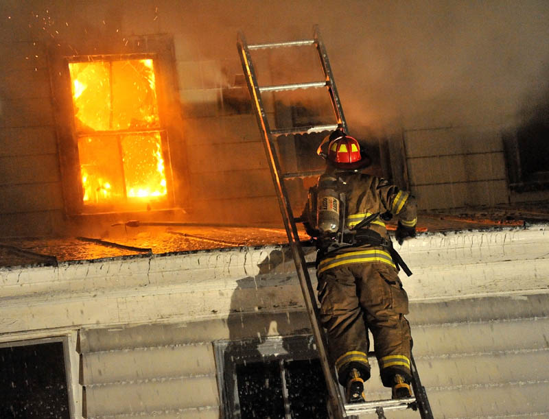 Staff photo by Michael G. Seamans Firefighters from Waterville and WinslowFire Departments responded to a structure fire on Water Street Monday evening. The apartment building was a total loss.