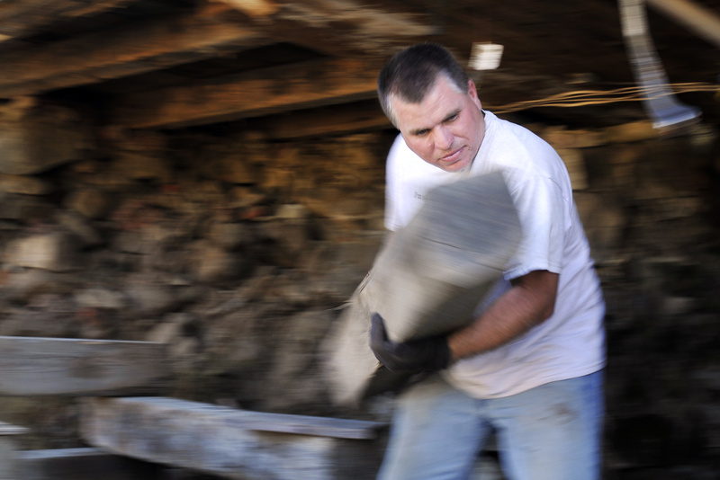 Gabe Souza/Staff Photographer: Ken Watson of Saco works to remove a support from underneath the Burnham House on Route 111 in Arundel, on Monday, September 12, 2011. The house, built in 1795, is one of two houses being raised from its foundation and moved by the Arundel Historical Society.