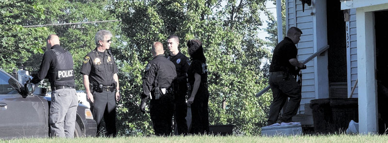 Winslow Police Chief Jeffrey Fenlason, second from left, speaks with other officers at a residence at 632 Benton Ave. in Winslow on Aug. 23.