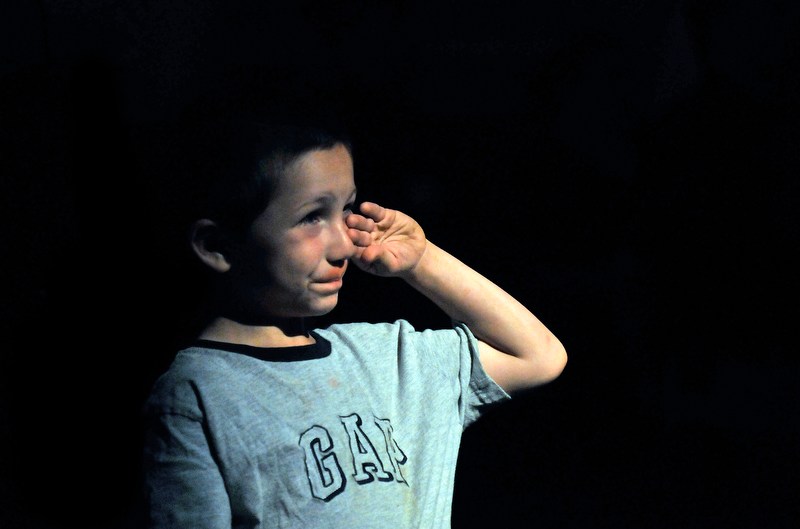 Staff photo by Michael G. Seamans Jasper Ruiz, 6, of North Anson, wipes a tear from his cheeck during the singing of the National Anthem at the beginning of the September 11th memorial sercvice at Champions on Main Street in Waterville Saturday.