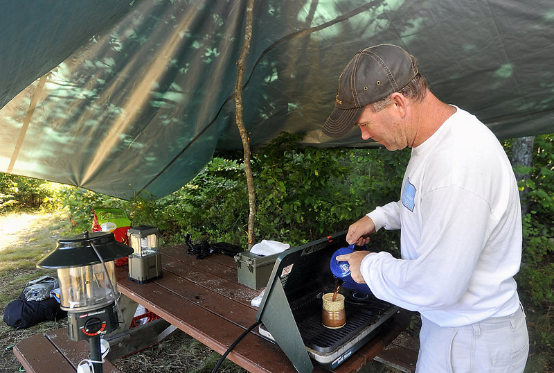 Peter Austin of Ellsworth pours a cup of coffee warmed on his camp stove at Donnell Pond. His family has camped at the reserve many times over the years and returned in August after a five-year hiatus.