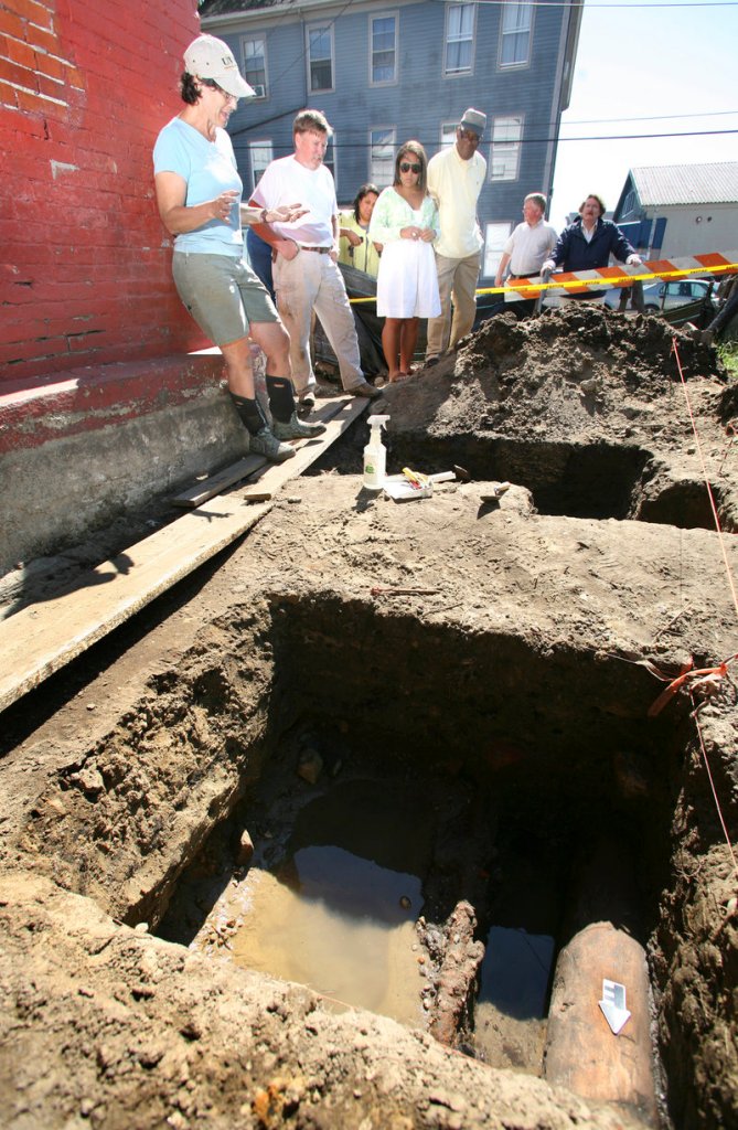 Archeologist Martha Pinello, far left, discusses the excavation at the historic Abyssinian Meeting House on Newbury Street where workers discovered early wooden underground water pipes that likely serviced area homes as well as the former Grandtrunk Railroad station in the mid-1800s.