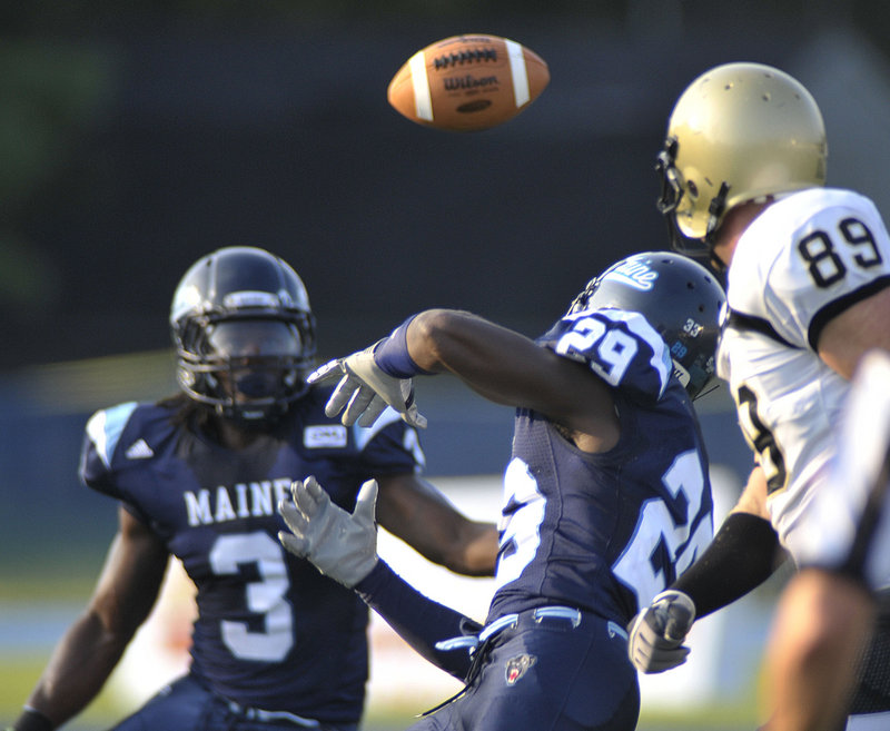 Darlos James (29) tries to knock down a pass intended for Bryant University’s Matthew Hunt, right, in the first quarter of Maine’s 28-13 victory Saturday at Orono.