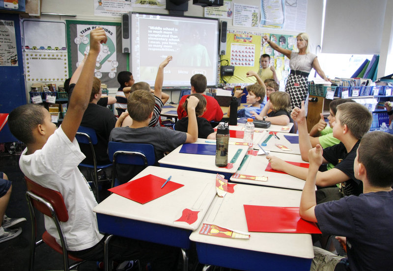 Jayquan Bowen, far left, votes with fellow sixth-grade boys on the differences between middle school and elementary school during Tracie Wagenfeld’s class at Willard School. The Sanford school has two single-gender sixth-grade classes and two single-gender fifth-grade classes.