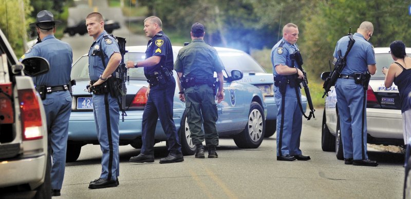 Police congregate outside a Farmingdale home Saturday after a neighbor opened fire inside the house.