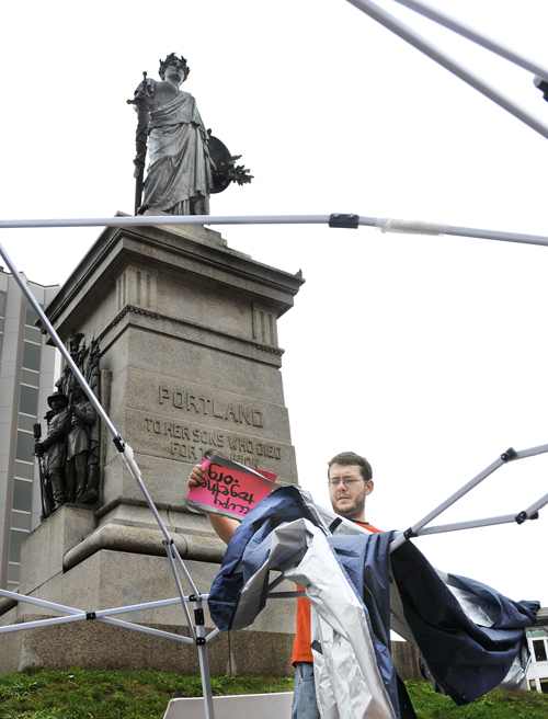 John Rasmussen, 27, who said he arrived in Portland last week and joined protests against Wall Street in Monument Square, packs up a tent after Portland police ordered demonstrators to take it down today.