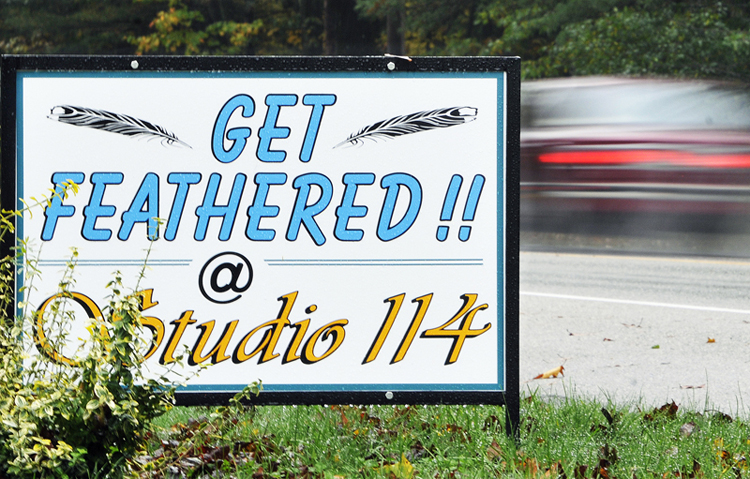 Studio 114 in Westbrook advertises its hair-feathering service with a sign that says “Get Feathered.” The salon charges $25 to attach multicolored feathers to a client’s hair.