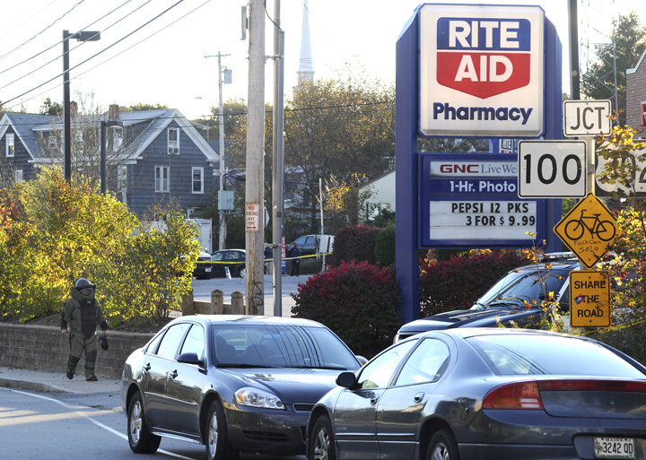 Portland police cars surround the scene as a member of the bomb squad checks out a suspicious device after a robbery at the Rite Aid on Forest Avenue today.
