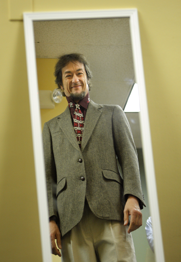 Matt Young checks out a suit in the mirror at the Career Center in Portland Tuesday. Young, a Portland musician, is seeking full-time work at an environmental nonprofit. He went home with a tweed jacket, slacks and tie.