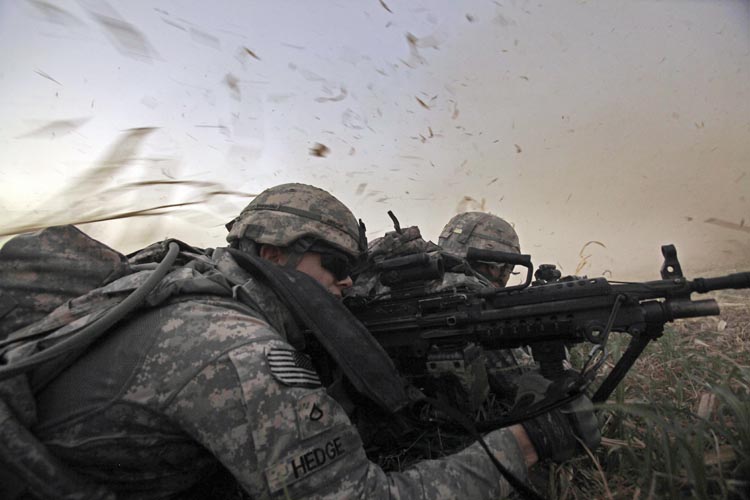 In this Aug. 8, 2011, photo, U.S. Army Pvt. 1st Class David Hedge from Bealeton, Va., front, and fellow soldiers from 1st Battalion, 18th Infantry Regiment, are bathed in rotor wash moments after arriving by Blackhawk helicopter for an operation to disrupt weapons smuggling in Istaqlal, north of Baghdad. President Barack Obama says all U.S. combat troops will come home from Iraq by the end of the year.