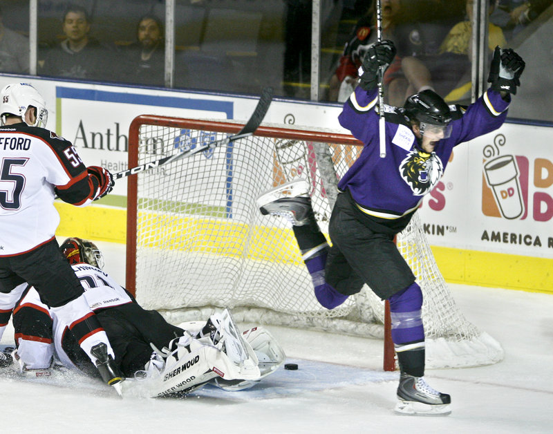 Cam Paddock of Manchester celebrates the Monarchs first goal as Portland's Garrett Stafford, left, and goalie Curtis McElhinney watch the puck cross the goal line in the first period Saturday night at the Cumberland County Civic Center.