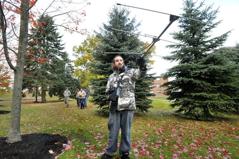 Senior Cory French uses a radio telemetry device to locate a squirrel near the Biddeford campus. He and a fellow student tracked one squirrel to a residential area and a bird feeder.