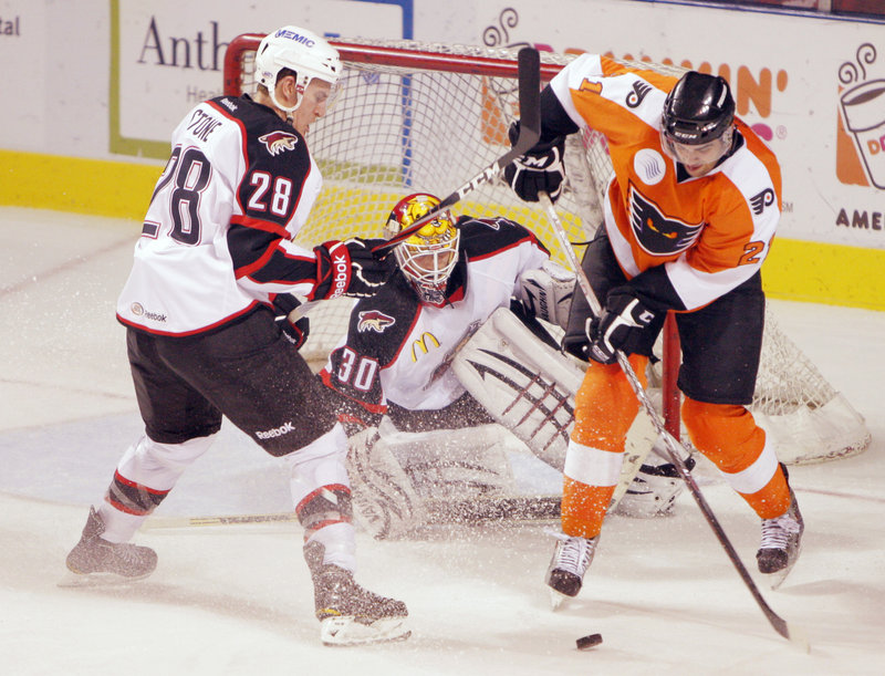 Tom Sestito of the Philadelphia Phantoms, right, attempts to turn for a move on Pirates goalie Marc Cheverie as defenseman Michael Stone helps out Tuesday night during Portland's 4-2 victory at the Civic Center.