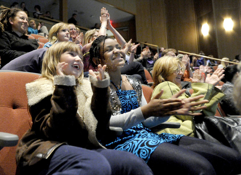 Laura Martin, 8, and Grace McCollum, 9, of Portland watch Waynflete graduate Michael Odokara-Okigbo and his group, the Dartmouth Aires, on “The Sing-Off” finals Monday night with a crowd of supporters in the school’s Franklin Theater.