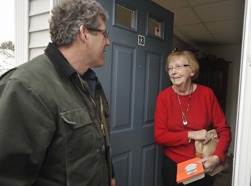 John Ewing/Staff Photographer... Sunday, December 20, 2011....The Southern Maine Agency on Aging has organized Meals on Wheels volunteers to deliver 231 holiday ham dinners throughout York and Cumberland counties. Members of the Portland Rotary Club distributed more than a hundred meals in the greater Portland area. Volunteer Greg Shinberg chats with Meals on Wheels client Kathy Porier at her Westbrook home after making a meal delivery.