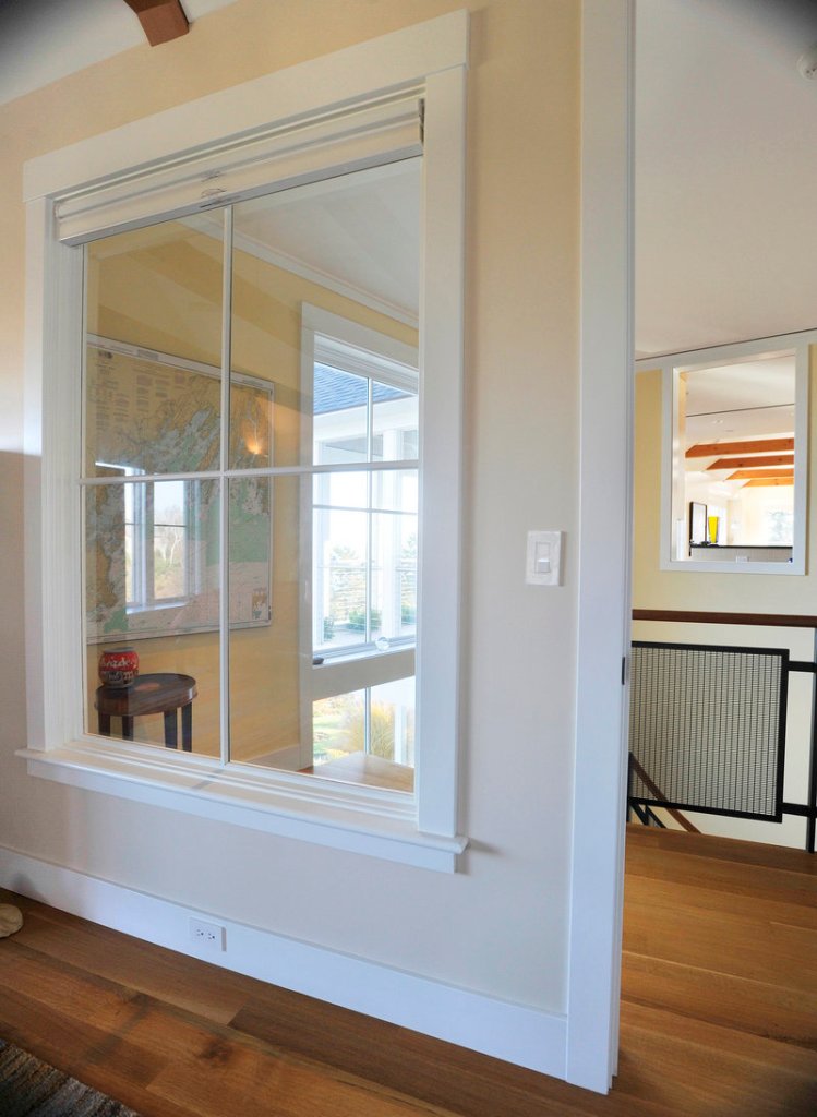 An interior window in the master bedroom looks out into the hallway and through another window to the kitchen/dining/living area.