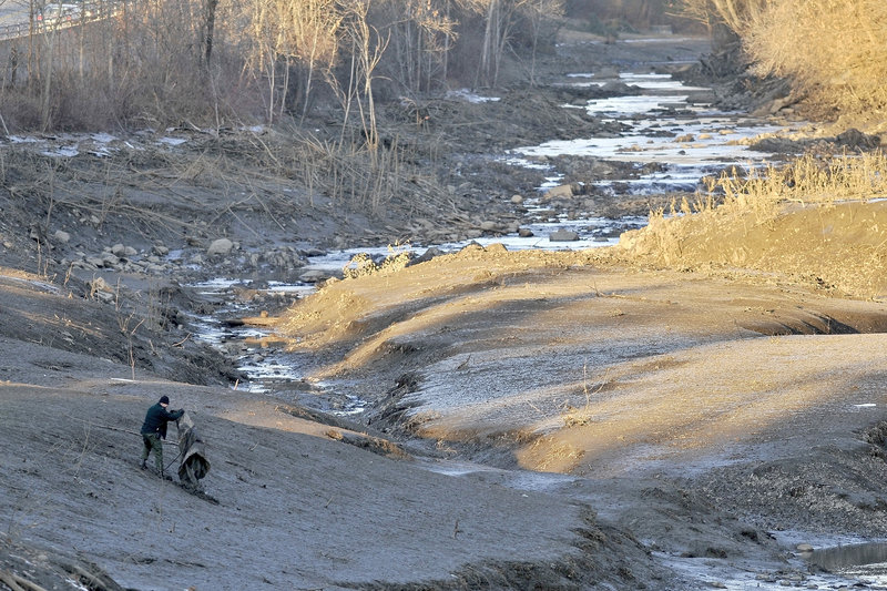 An investigator sweeps along the banks of a section of Messalonskee Stream near West River Road in Waterville on Tuesday that had been drained as authorities continued their search for 20-month-old Ayla Reynolds, who was reported missing from her father’s home Saturday morning.