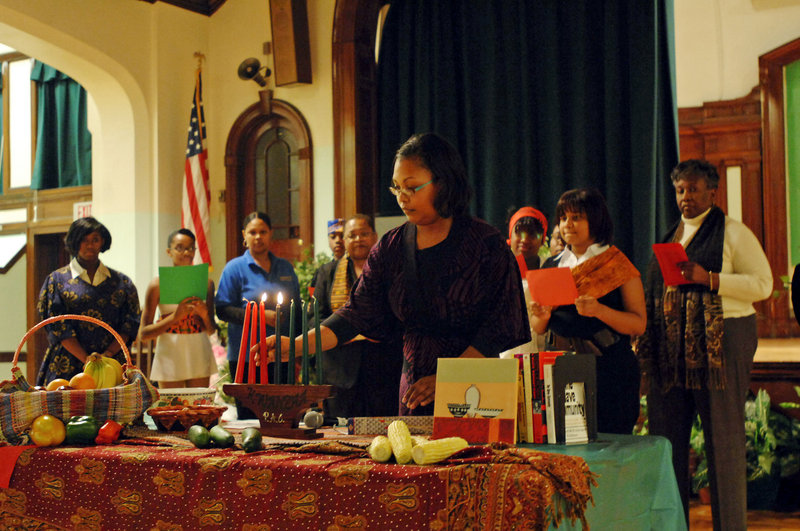 Jonnie N. DeLoach lights candles at a Kwanzaa celebration in Paterson, N.J., this week. During the seven-day holiday, a candle is lit each day, representing principles such as unity, self-determination, collective work, creativity and faith.