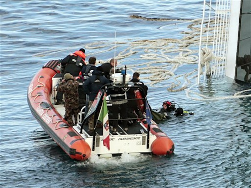 In this photo, Italian naval divers recover a body from the cruise ship Costa Concordia. The $450 million ship was carrying more than 4,200 passengers and crew when it slammed into a reef on Friday, Jan. 13, following an unauthorized maneuver by the captain. (AP Photo/Gregorio Borgia)