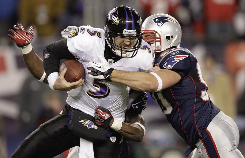 James Ihedigbo, behind, and Rob Ninkovich tackle Ravens quarterback Joe Flacco in Sunday’s AFC title game at Foxborough, Mass.