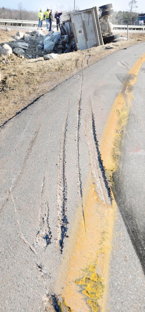 WRECK: Gouged asphalt and skid marks were left Tuesday when a dump truck overturned on the exit 113 off-ramp on Interstate 95 in Augusta. The truck was leaving the interstate and tipped over just before getting onto Route 3.