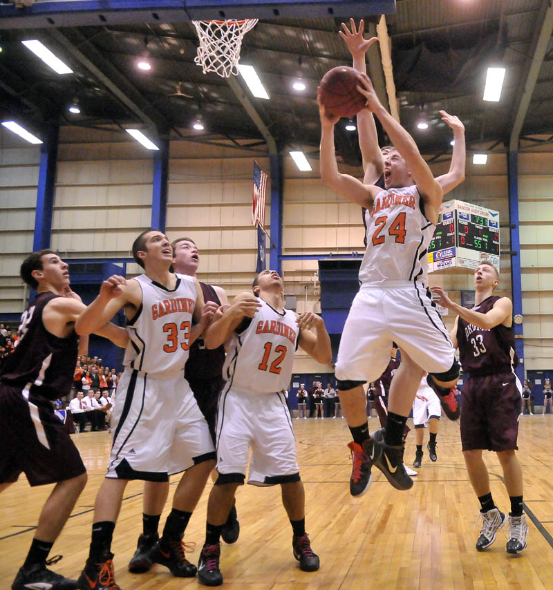 Gardiner High School's Matt Hall, 24, right, drives to the basket in the first half of the Eastern Class B quarterfinals game at the Bangor Auditorium Friday. Gardiner won 56-47 in over time.