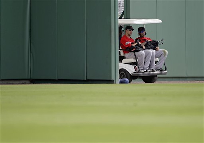 Boston Red Sox's Ryan Kalish, left, and Darnell McDonald are driven out of the ball park on a golf cart to a practice field during a baseball spring training workout Tuesday, Feb. 28, 2012, in Fort Myers, Fla. (AP Photo/David Goldman)