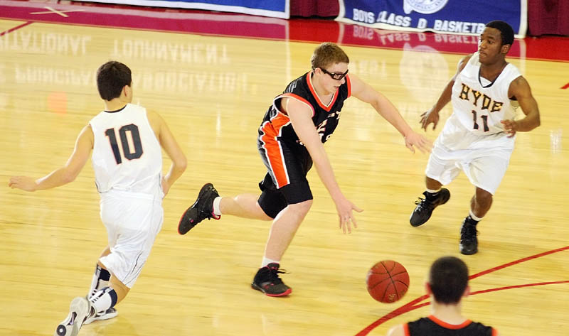 Forest Hills guard Derick Ouellette drives between Hyde defenders Wilson MacMillan, left, and Tyqyan Ekejiuba.