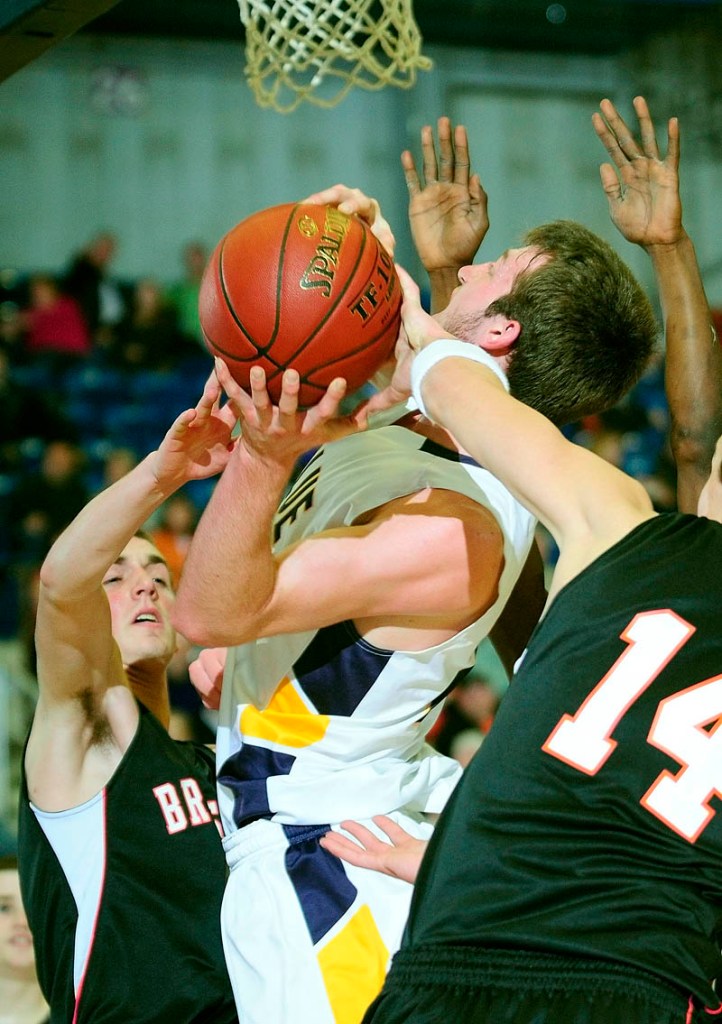 Staff photo by Joe Phelan Mt. Blue's Cam Sennick, center, is swarmed by Brunswick defenders Ryan Black, left, and Trent Anderson during the Class A East tournament on Saturday afternoon at the Augusta Civic Center.