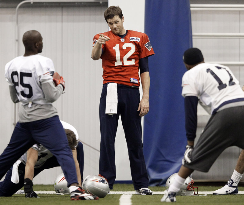 Tom Brady has some words with wide receiver Chad Ochocinco, left, and Britt Davis of the practice squad, during Wednesday’s practice for the Super Bowl in Indianapolis.