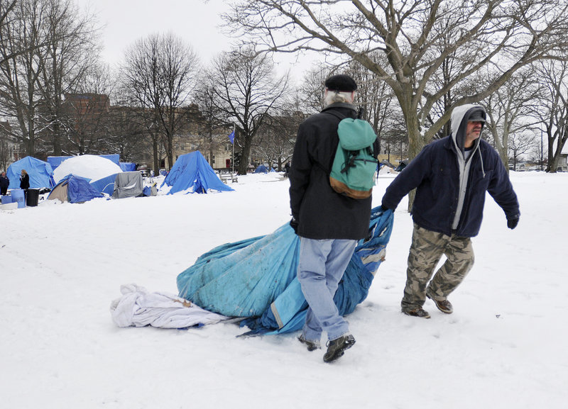 Steve Demetriou, left, and Deese Hamilton drag a tent through Lincoln Park to a Dumpster Thursday.