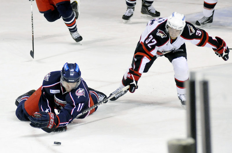 Adam Mair of Springfield dives for a loose puck and lands on Ryan Duncan’s stick during Sunday’s game at the Cumberland County Civic Center. The Falcons beat the Pirates, 6-2. Springfield has won 5 of seven against the Pirates.