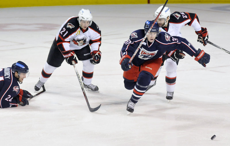 Matt Calvert of Springfield goes after the puck while being chased by Portland’s Andy Miele and Mathieu Beaudoin in Sunday’s game at the Cumberland County Civic Center. The Falcons won 6-2, the Pirates’ 10th loss in their last 14 games.