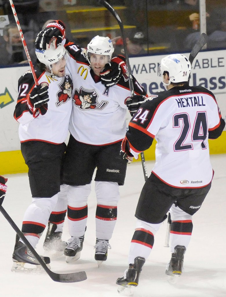 Nick Ross, left, celebrates his first-period goal with Pirates teammates Matt Watkins and Brett Hextall. It was Ross’ first AHL goal since April 8, 2008.