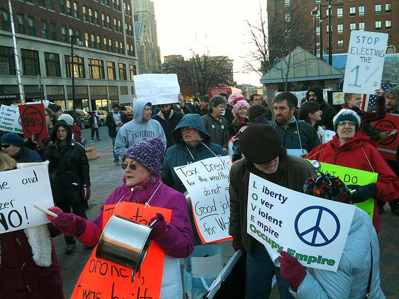 Protesters gather in Congress Square, Portland, Friday, March 30, 2012, across from the Portland Museum of Art where President Obama is attending a high-priced fund-raising event.