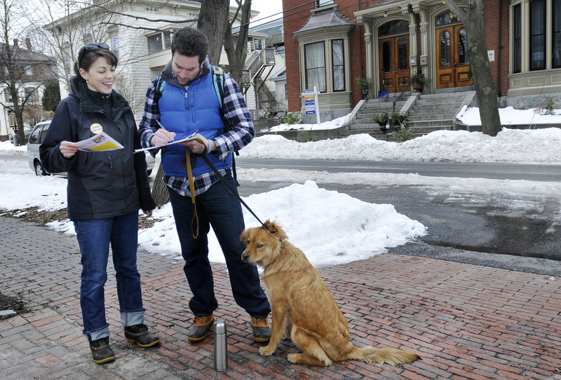 Stephanie O’Brien of Portland collects signatures to get Democrat Jon Hinck on the ballot as a candidate for the 1st District congressional seat. Signing is Justin Moss of Portland. O’Brien was going door to door on Carleton Street in Portland on Sunday.