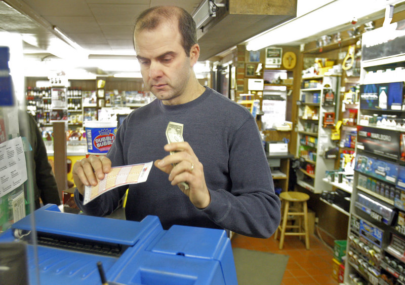 Tim Discatio runs a customer’s Mega Millions numbers through a lottery machine Thursday at Joe’s Smoke Shop in Portland, which was busy selling tickets for tonight’s $540 million drawing.