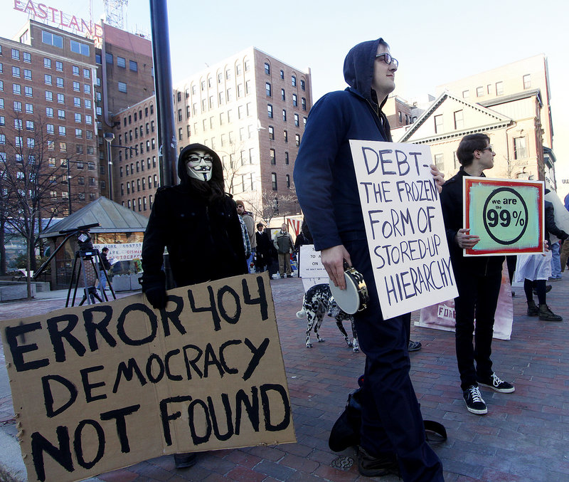 Protesters set up on Congress Street as President Obama visits the Portland Museum of Art on Friday. From left are Zach Figoli, Jake Lowry and Adam Marletta, all of Portland.