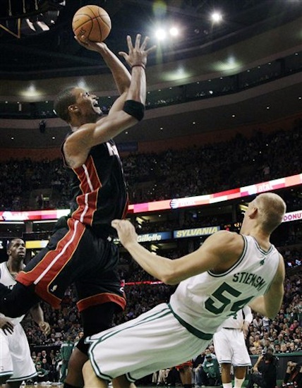 Boston Celtics center Greg Stiemsma (54) draws an offensive foul on Miami Heat power forward Chris Bosh as he shoots in the first half of an NBA basketball game in Boston, Sunday, April 1, 2012. (AP Photo/Elise Amendola)