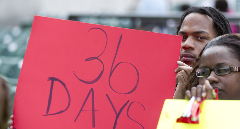 Keon McCloud holds a sign referring to the 36 days that have passed since 17-year-old Trayvon Martin was shot to death, as thousands gathered for a rally in Miami on Sunday.