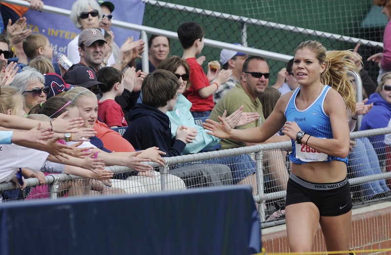 Erica Jesseman delivers high-fives as she approaches the Hadlock Field finish line of the Sea Dogs Mother’s Day 5K Road Race. Jesseman has been dealing with injuries but still delivered a winning margin of 42 seconds.