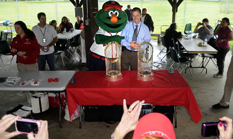 Ryan Lilly is mobbed by Wally the Green Monster and photographers Wednesday during an appearance of the Red Sox World Series Trophies at the federal health care facility for veterans. The Fenway Ambassadors visited Togus where Lilly is the Medical Center Associate Director.