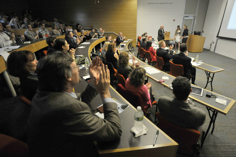 In background at right, Lynn Peel and Nova Ewens of Beach Glass Transitions finish their presentation before a crowd of venture capitalists, business executives and professors at USM. Beach Glass is a provider of advice and support services for care of the elderly.